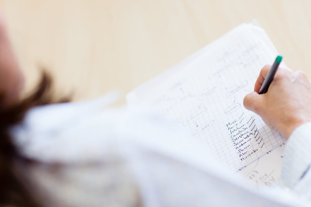 Teacher with attendance list ticking names of students Teacher with attendance list ticking names of students